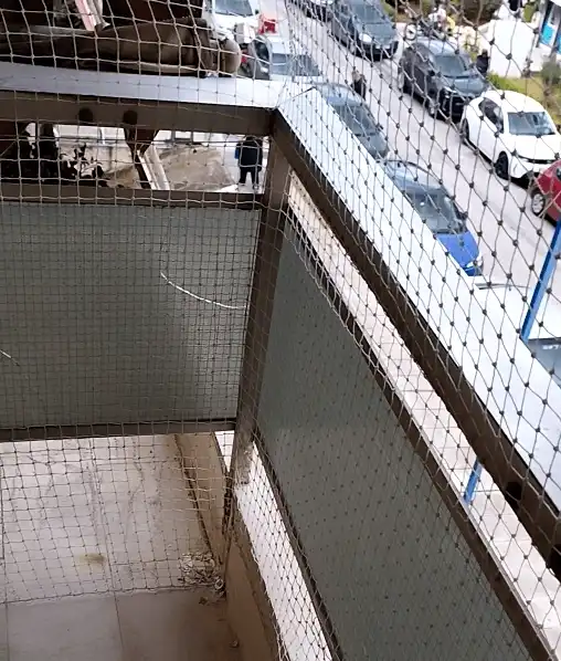 Μεγαλωμένη εικόνα από την τοποθέτηση διχτυού σε ένα μπαλκόνι με κενό από κάτω καλυμμένο